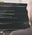 Een persoon die voor de computer zit en werkt aan een website.