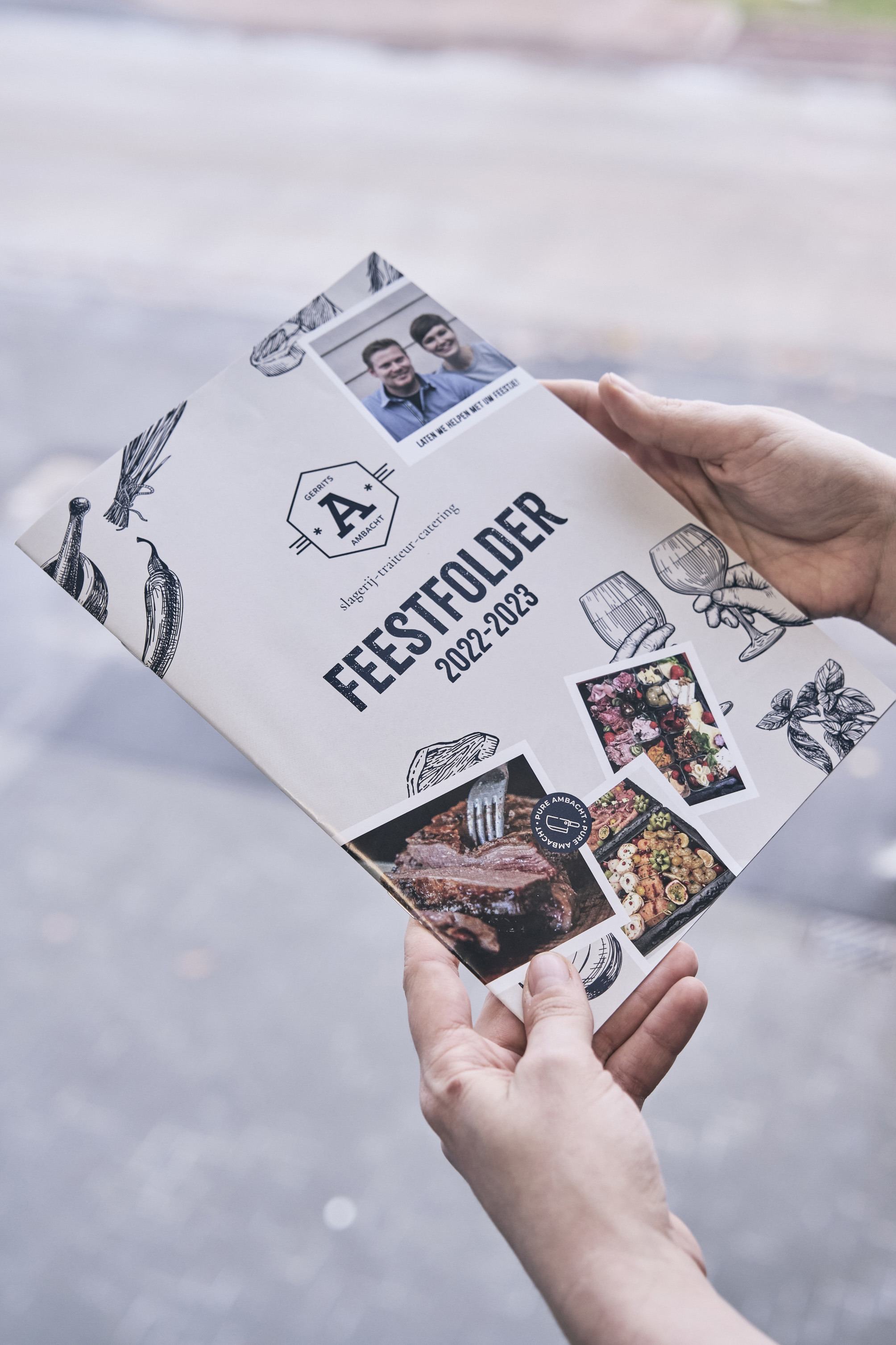 Persoon houdt feestfolder 2022–2023 van Slagerij A vast.